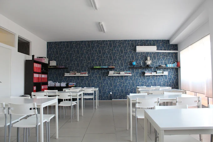 Sala de estudo do Acima da Média, com mesas brancas e estantes com livros